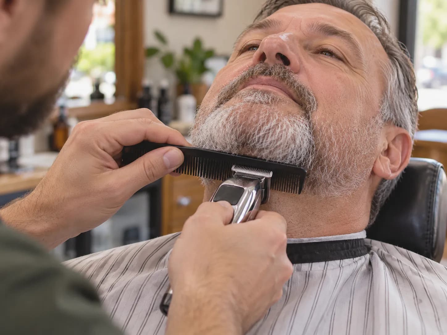Shaping a graying beard with a comb and a clipper